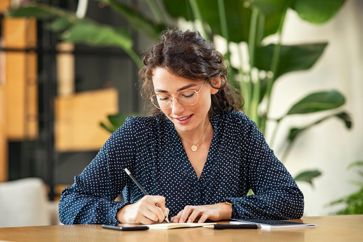 woman writing down notes on agenda
