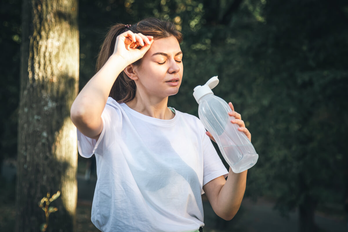 attractive young woman drinks water after logging